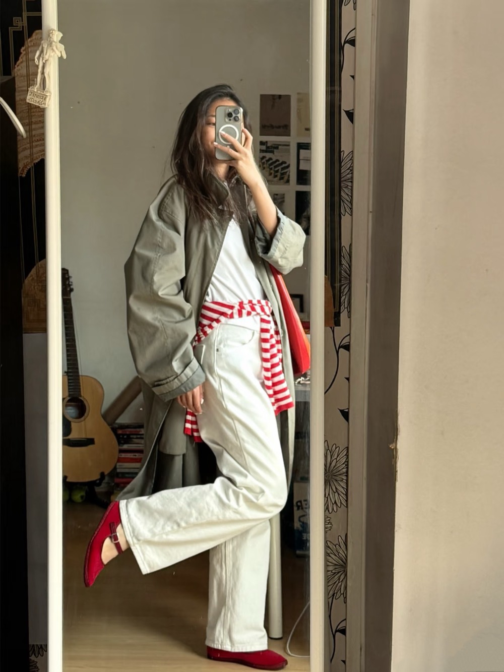 Sage utility jacket over white jeans with a red striped knit tied at the waist and red flats
