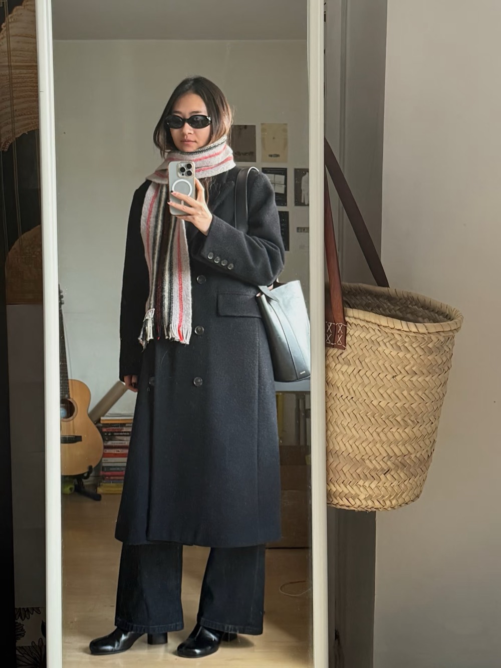 Long dark wool coat with a red and cream striped scarf, wide denim and a straw basket bag